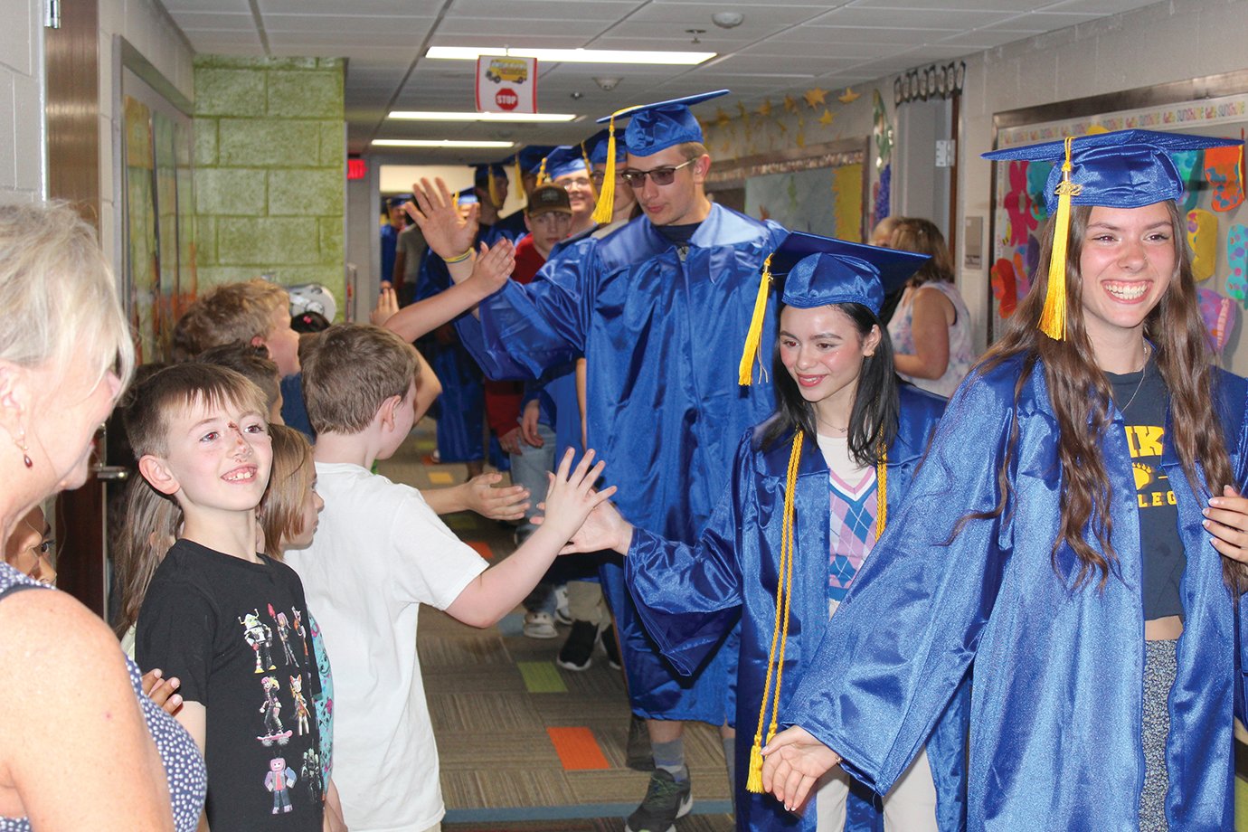 Graduating Athenians give out “high fives” and “fist bumps” Tuesday to Hose students during the Senior Walk.